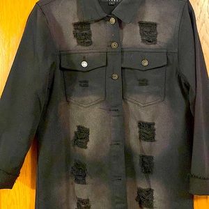 This is a quarter length black jean jacket with the bottom cut slits.